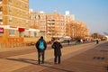 An adult couple walks along the boardwalk on a winter`s day