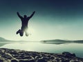 Adult crazy man jumps near water on against red sunset. Empty beach Royalty Free Stock Photo