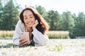 Adult curly hair smiling woman in casual using mobile phone in city park Royalty Free Stock Photo