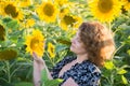 Adult curly-haired woman in field of sunflowers Royalty Free Stock Photo