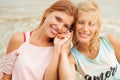 Adult daughter holds mom`s hand outdoors and both are smiling