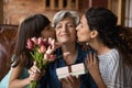 Adult daughter little granddaughter greeting mature latin lady with birthday Royalty Free Stock Photo