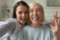 Adult daughter and senior mom taking selfie together Royalty Free Stock Photo