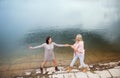 Adult daughter spending time with her mother, having fun, laughing. Mom and daughter outdoors, on walk by reservoir Royalty Free Stock Photo