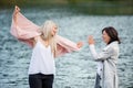 Adult daughter spending time with her mother, having fun, laughing. Mom and daughter outdoors, on walk by reservoir Royalty Free Stock Photo