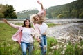 Adult daughter spending time with her mother, having fun, laughing. Mom and daughter outdoors, on walk by reservoir Royalty Free Stock Photo