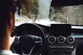Portrait of adult driving a modern car on forest road during winter drive Royalty Free Stock Photo