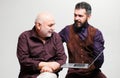 Adult education. Happy young man with senior dad have fun watching funny video on laptop, smiling elderly father and Royalty Free Stock Photo