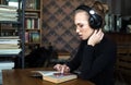 Adult education, student in headphones working in the library or classroom of university Royalty Free Stock Photo