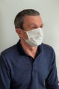 An adult elderly man in a medical mask because of a coronavirus.