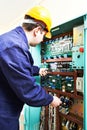 Adult electrician builder engineer worker testing electronics in switch board