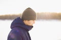 Adult european caucasian white male man in winter clothes on frozen lake. Side view, profile of young man against sun. Lifestyle