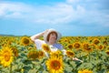 Adult european woman in a white hat on a field with sunflowers, summer sunny day in the countryside Royalty Free Stock Photo