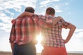 Adult father and son holding hands at sunset