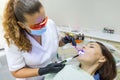 Adult female dentist treating patient woman teeth. Medicine, dentistry and healthcare concept