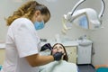 Adult female dentist treating patient woman teeth. Medicine, dentistry and healthcare concept