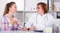 Adult female doctor leading medical appointment Royalty Free Stock Photo