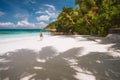 Adult female enjoy tropical white sand beach, palm trees and blue ocean lagoon. Exotic paradise island recreation Royalty Free Stock Photo
