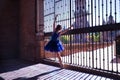 Adult female Hispanic classical ballet dancer in blue tutu making figures on metal gratings against the light