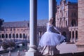 Adult female Hispanic classical ballet dancer making figures between two stone columns, wearing a white tutu