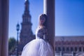 Adult female Hispanic classical ballet dancer making figures between two stone columns, wearing a white tutu