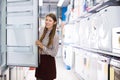 Adult female housewife buying large refrigerator