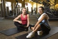 Adult female with personal trainer at gym. Royalty Free Stock Photo