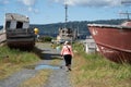 Adult female wanders through an abandoned boat shipyard graveyard