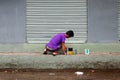 Adult Filipino man painting wall of building