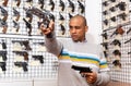 Adult focused latin american man aiming with pistol