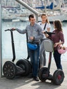 Adult friends with segways near sea