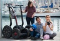 Adult friends with segways near sea