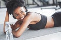Adult girl lying down and resting. African american woman with curly hair and in sportive clothes have fitness day in