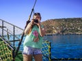 Adult girl photographer with a camera in her hands against the backdrop of a seascape with Alanya Old Town Turkey. Young woman Royalty Free Stock Photo