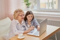 Adult granddaughter teaching her elderly grandmother to use laptop Royalty Free Stock Photo