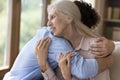 Adult grandson greeting grandma at home, hugging with warmth Royalty Free Stock Photo