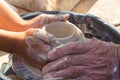 adult hand fed baby& x27;s hands to work with a potter& x27;s wheel Royalty Free Stock Photo