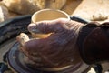 adult hand fed baby& x27;s hands to work with a potter& x27;s wheel Royalty Free Stock Photo