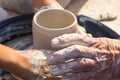 adult hand fed baby& x27;s hands to work with a potter& x27;s wheel Royalty Free Stock Photo