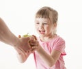 Adult hand giving a green apple for pretty little girl