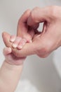 Adult hand holding her newborn baby`s hand on white background. Childhood, family, birth concept Royalty Free Stock Photo