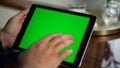 Adult hand swiping green tablet screen closeup. Man holding chroma key computer Royalty Free Stock Photo