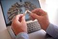 Adult hands holding a broken cigarette over laptop keyboard, ready stop smoking. World tuberculosis day, world no tobacco day, Royalty Free Stock Photo