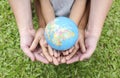 Adult hands holding kid hands with red apple on top