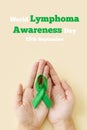 Adult hands holds green. World lymphoma awareness day. September 15. Cancer and Lymphoma Awareness month.