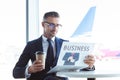 adult handsome businessman reading newspaper and holding coffee to go Royalty Free Stock Photo