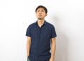 Adult handsome Chinese man wearing blue shirt standing over isolated white background feel depressed Royalty Free Stock Photo