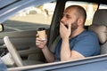 Adult handsome man feeling tired and yawning while driving a car. Driver having coffee early morning in avto Royalty Free Stock Photo