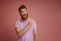 Adult handsome stylish redhead bearded smiling man pointing aside