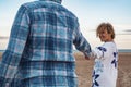 Adult happy couple in love holding hands and walking together at the beach enjoying winter holiday vacation. Outdoor leisure Royalty Free Stock Photo